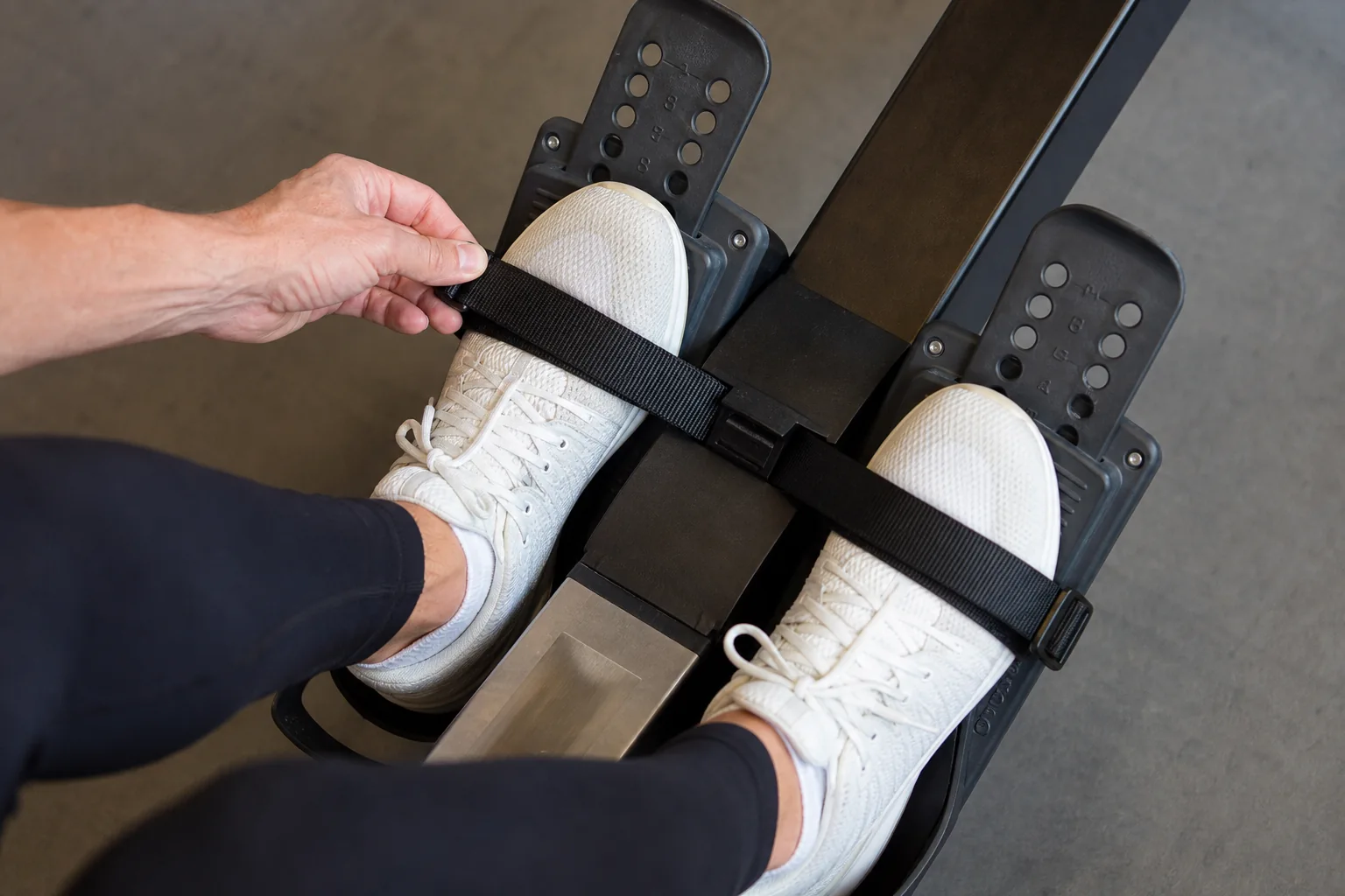Rowing shoes held in adjustable heel cups with straps across the broad forefoot